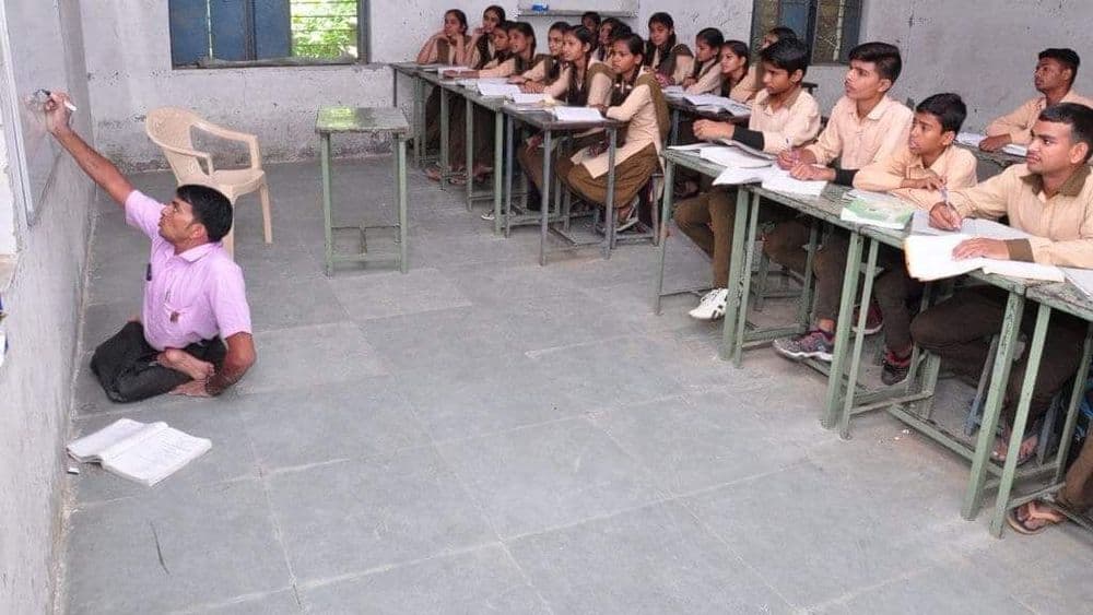 अपंगत्वावर मात करणारे हे शिक्षक आहेत तरी कोण ? वाचा व्हायरल फोटो मागची कहाणी !!
